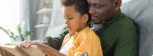 father reading book to child